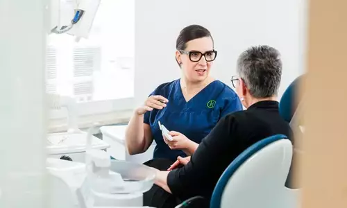 Zahnärztin berät Patientin im Behandlungszimmer zur Parodontologie in Dornbirn